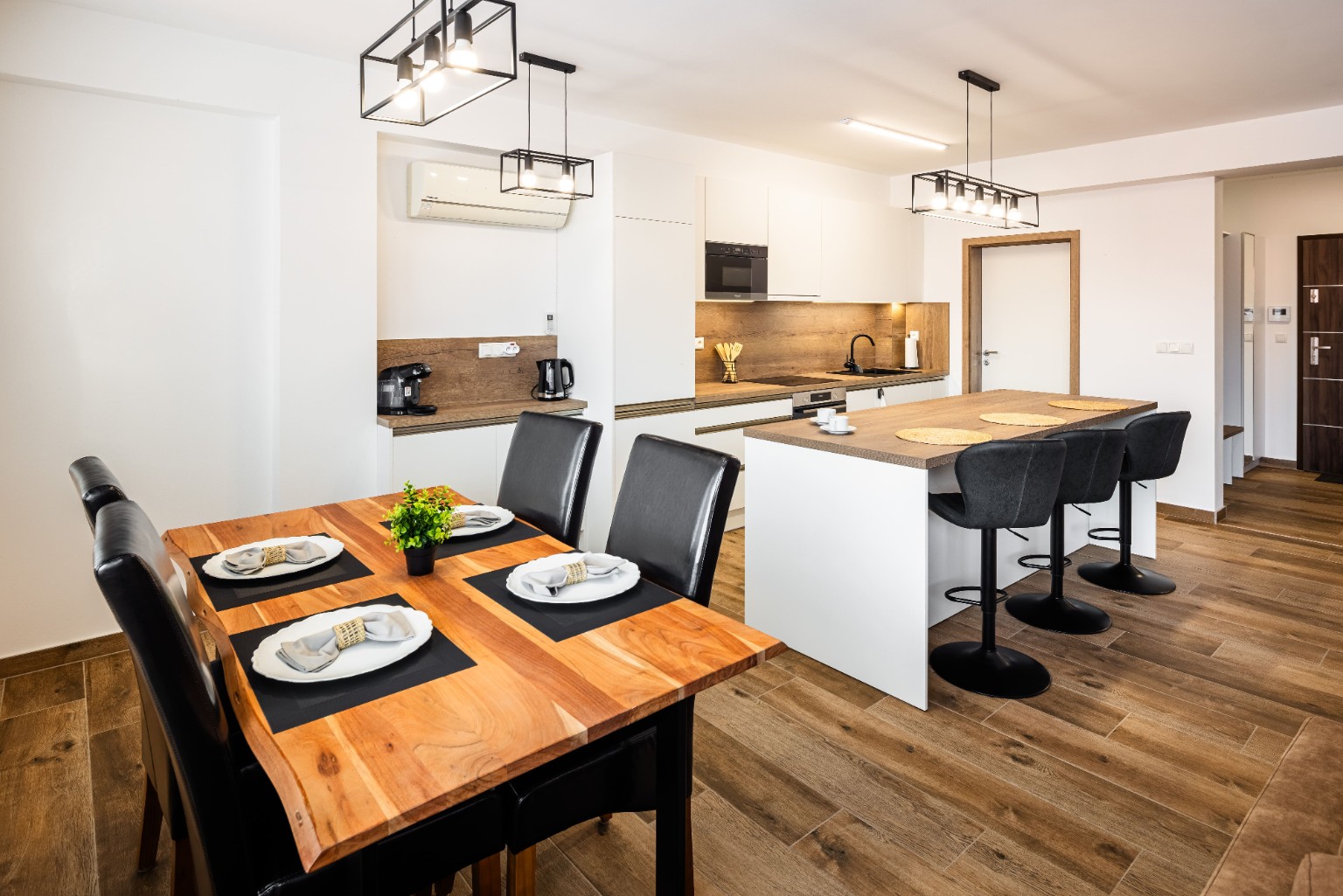 Large wooden dining table and white kitchen in City Center Gallery