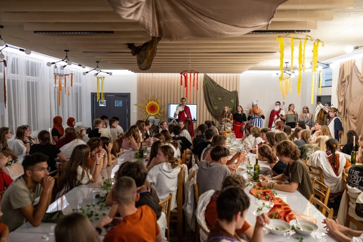 A large group seated together in the dining and common hall
