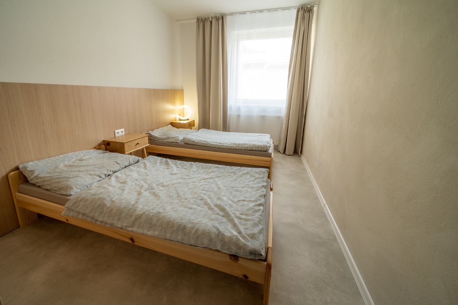 Bedroom with double and single beds at Cabin Retreat