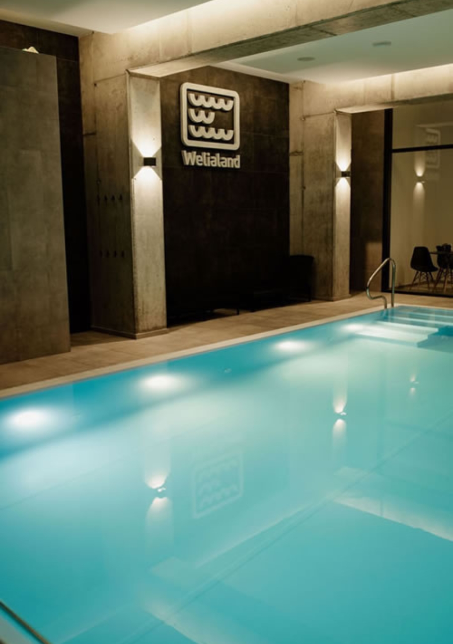 Indoor swimming pool with illuminated water and entry steps in the spa at Riverview.